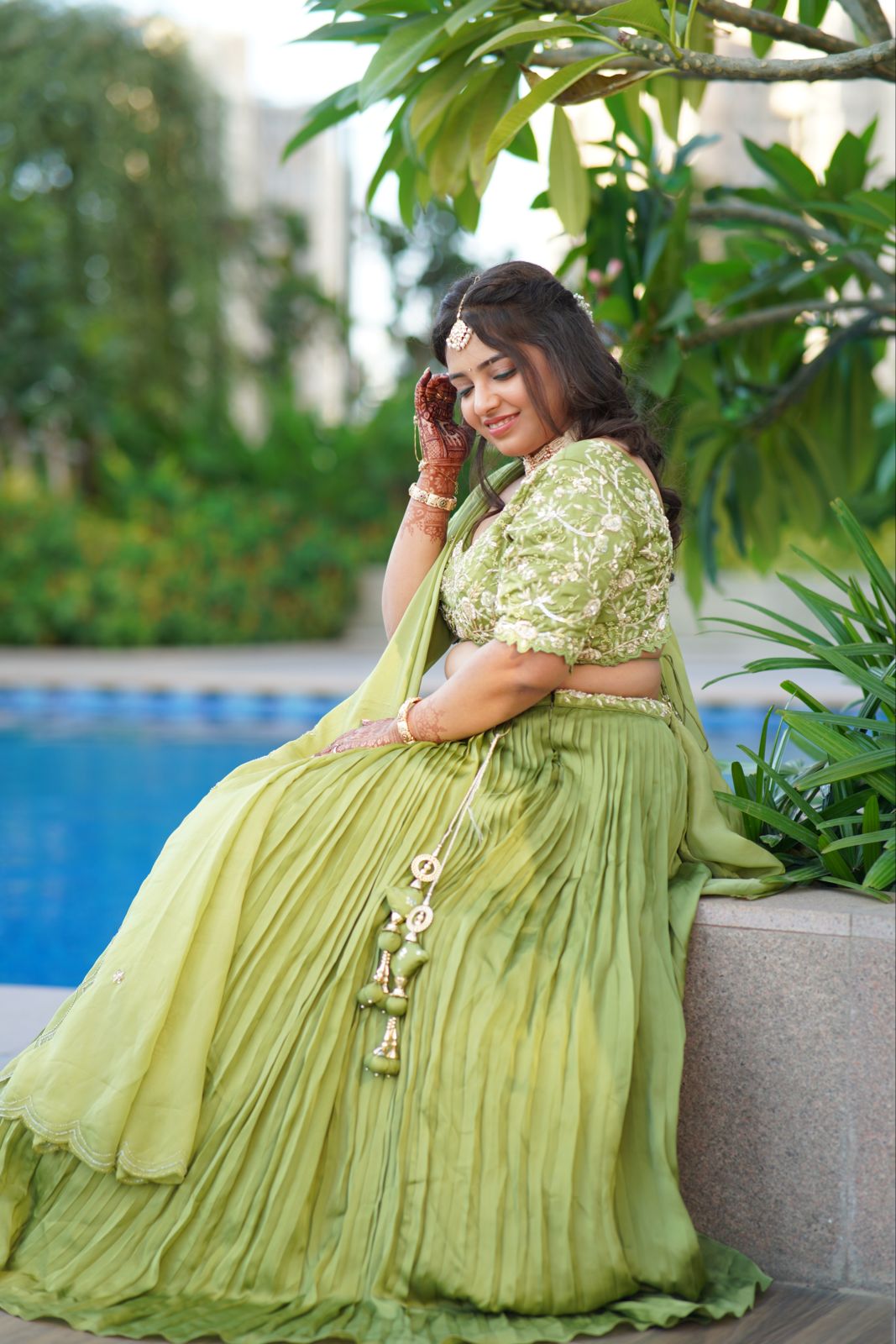 Bride in green by a pool